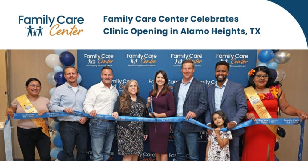 employees smiling and holding up a ribbon at a clinic opening event